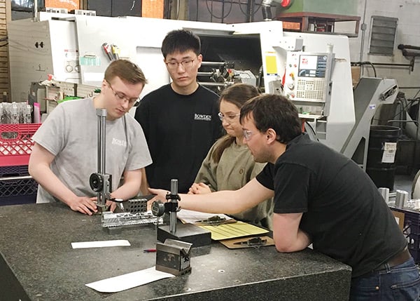 Nate Tompkin, Bowden’s first entry-level mechanical engineer to graduate from the company’s two-year program, teaches a group of interns some metrology basics. (Provided by Bowden Manufacturing)