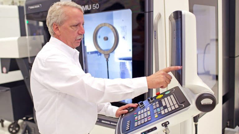 A DMG employee showcasing the DMU 50 with Siemens’ 840D sl CNC. The features of the 840D allow a streamlined simulation of the actual cutting path.